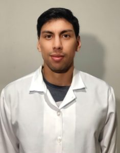 Professor Guilherme Carneiro de pé usando jaleco branco