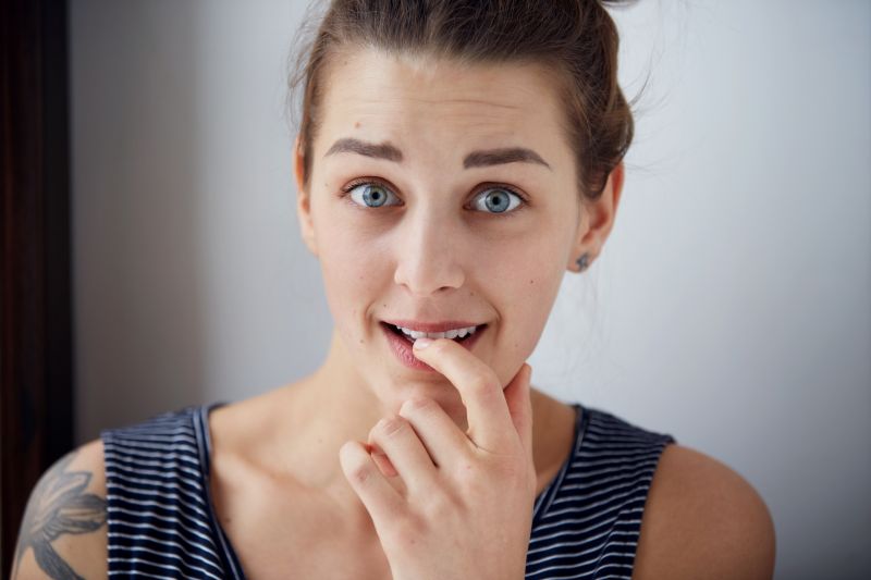 Embarrassed woman. Closeup portrait woman looking ashamed or shy in full disbelief isolated grey wall background. Positive human emotion facial expression body language. Funny girl