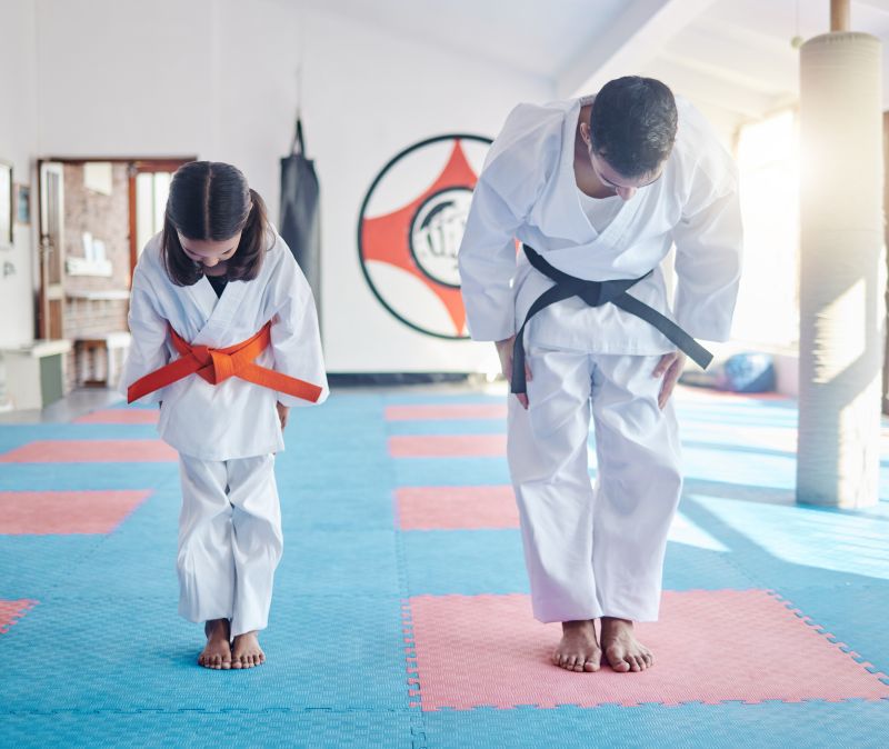 Give respect, get respect. Shot of a young man and cute little girl practicing karate in a studio